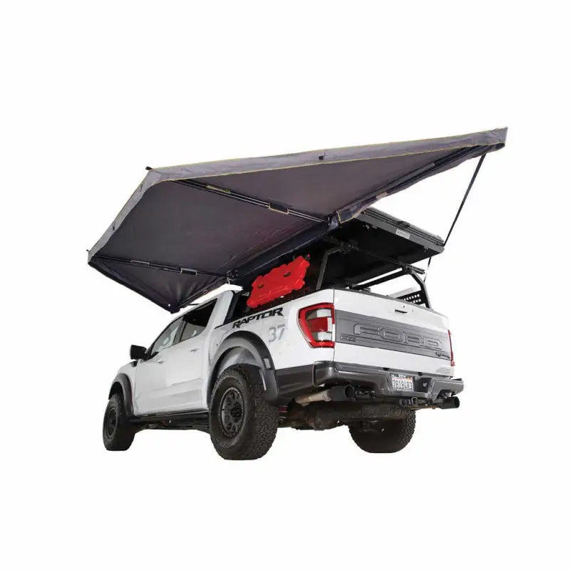 White Ford Raptor pickup truck with 19609917 Overland Vcl Nomadic Lte awning setup