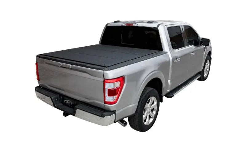 Silver pickup truck with black lomax bed cover and running boards on ram classic