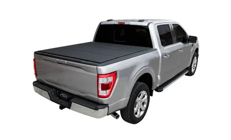 Silver pickup truck with black lomax bed cover and running boards on ram classic