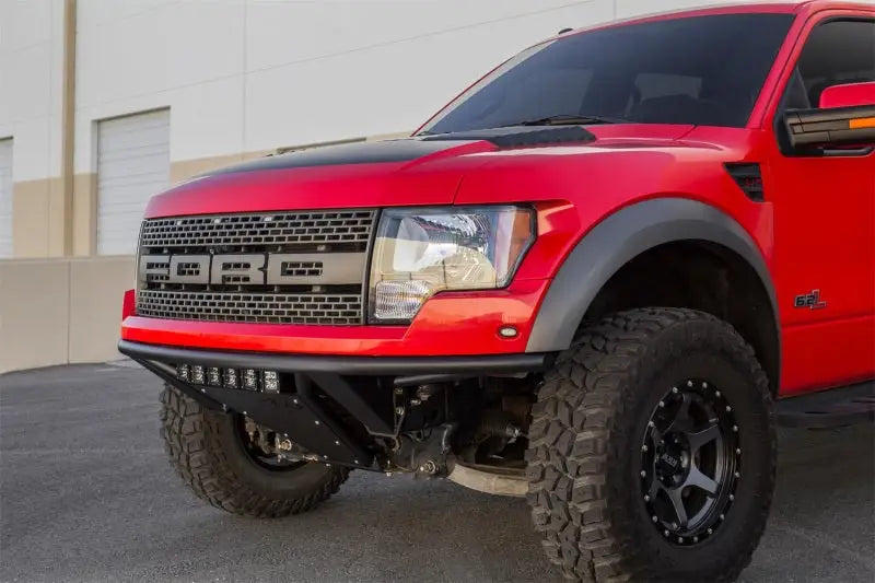 Red Ford Raptor truck with Addictive Desert Designs ADD PRO Front Bumper
