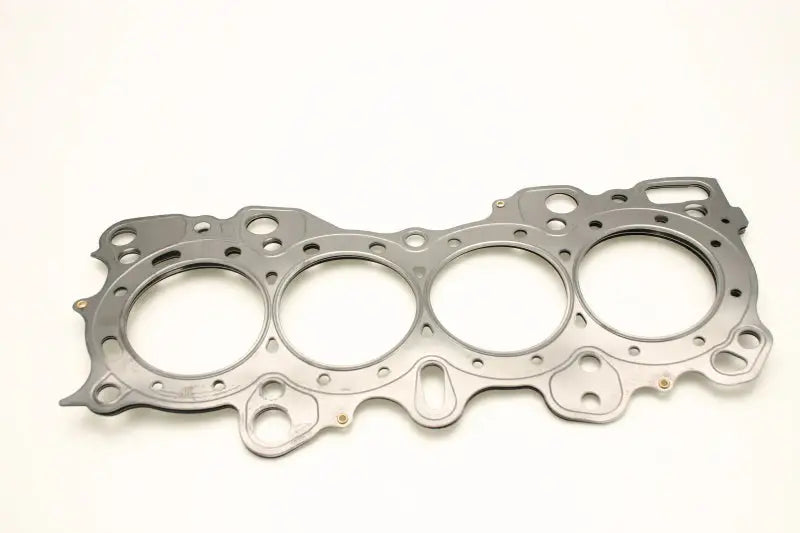 A Cometic Gasket Honda CRX/Civic/Integra - VTEC 81mm .030 inch MLS Head Gasket, featuring four round cylinder openings and multiple bolt holes, is showcased against a plain white background. This intricately shaped gasket is designed to fit over the engine block's cylinders and maintain a perfect seal.