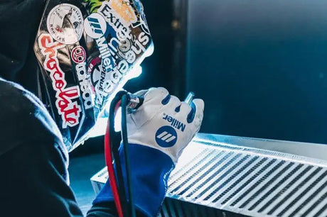 Welder working on a high performance CSF intercooler core with protective gear