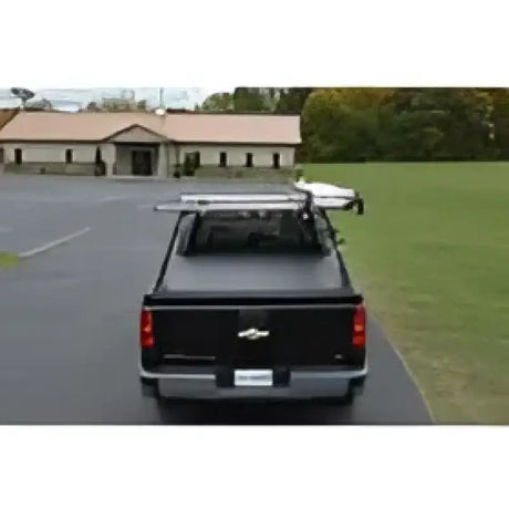 Black pickup truck with bed cover and ladder rack.