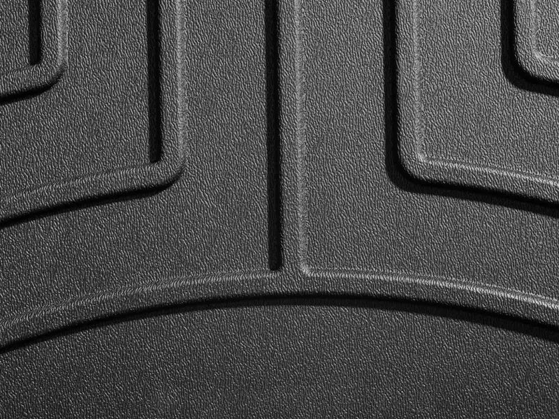 Close-up of WeatherTech black thermoplastic polyolefin (TPO) floor liner showing molded channels and textured surface for fluid control.