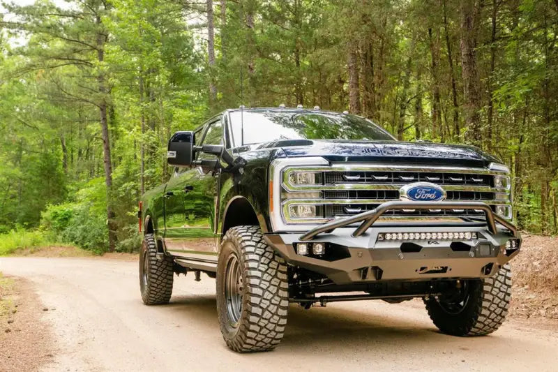 FS23-X5952-1 Fab Fours Matrix Front on a rugged off-road truck in a forest setting, showcasing high-quality construction and aggressive styling for maximum protection, Bumpers, Grilles & Guards, AVADA - Best Sellers, Must Haves