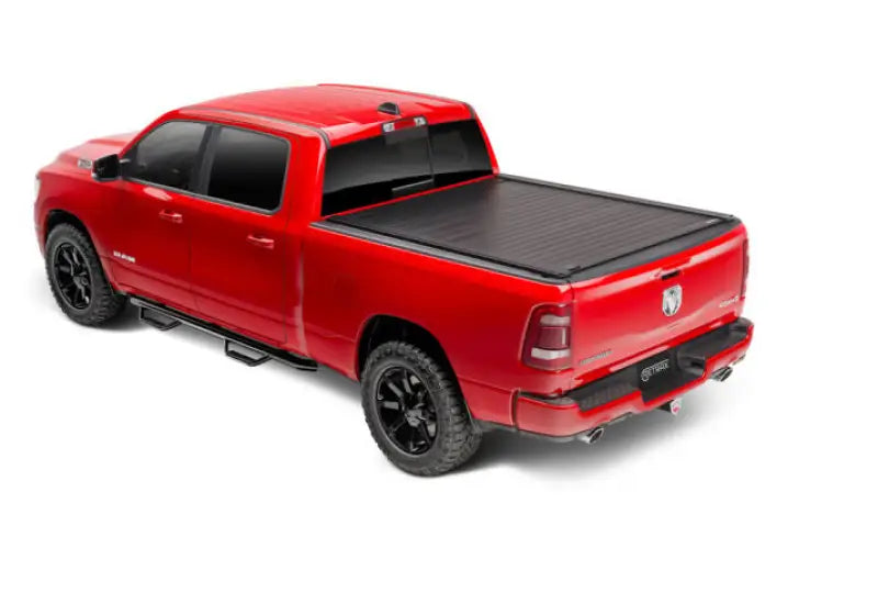 Red pickup truck with black matte manual retractable tonneau cover and trax rail system