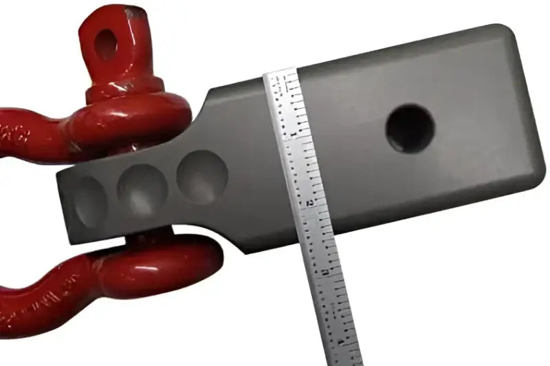 Factor 55 Hitchlink Pro 2.5 for 2.5' receivers showcasing durable construction with a red hitch accessory and measurement tool.