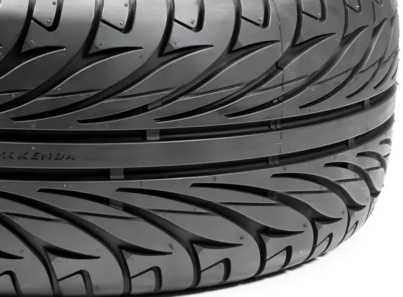 Black car tire with directional tread on 042015001a1 Kenda Kanine 165/55R-15 wheel