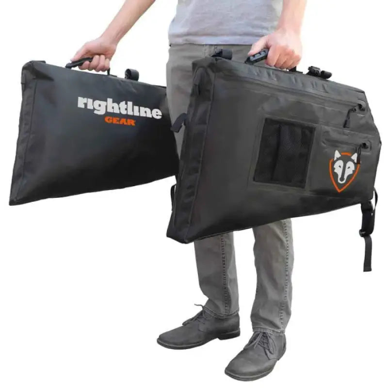 Black storage bags with handles held by a person for 100J75-B Rightline Side Storage Bag