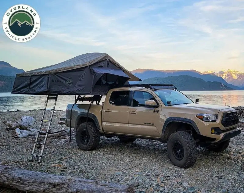 Tan pickup truck with overland VCL Nomadic extended roof top tent for adventures