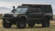 Modified green Toyota Tacoma pickup truck with Sherpa Equip Taccoma Camper for outdoor adventures