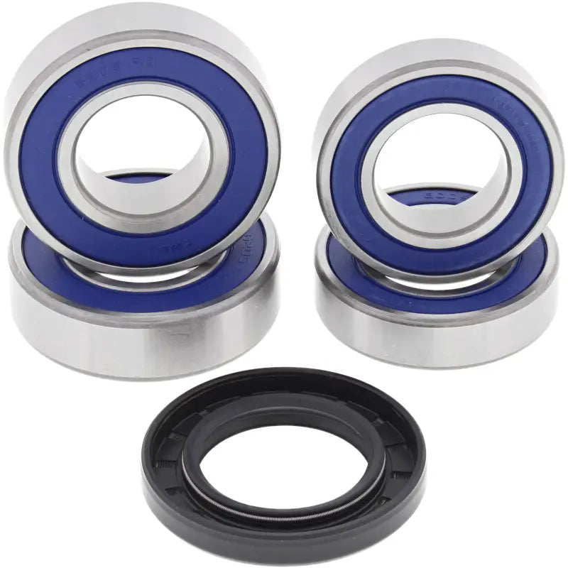 Four silver ball bearings with blue seals and a black rubber seal in a wheel bearing seal kit