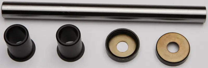 Metal shaft with black plastic bushings and brass washers in Swingarm Bearing Kit