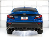 Blue Subaru WRX with AWE Track Exhaust displayed in a garage, showcasing dual exhaust pipes and AWE branding on the license plate.