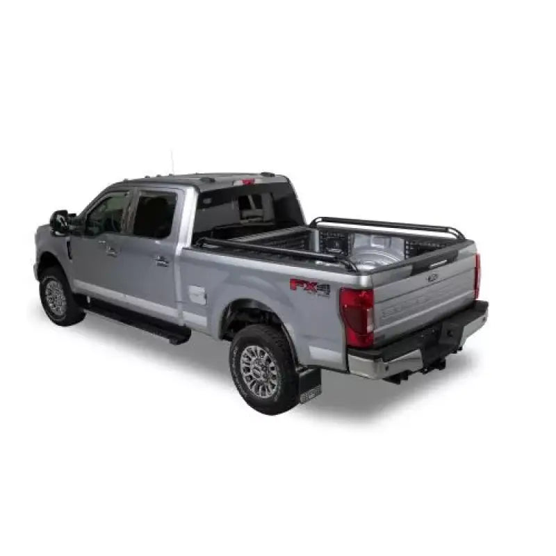 Silver pickup truck with bed rails.