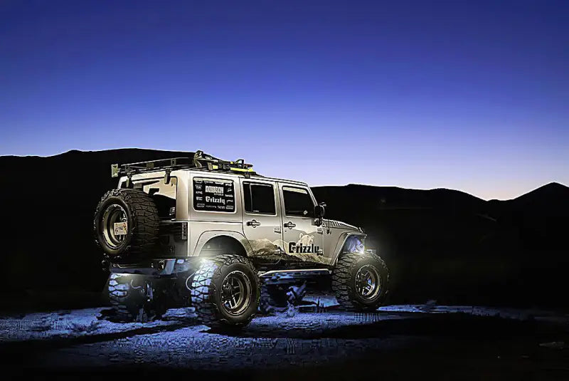 Silver off-road Jeep showcasing the 5875-001 Oracle Light Wheel Well Rock Light Kit Wht 4Pc