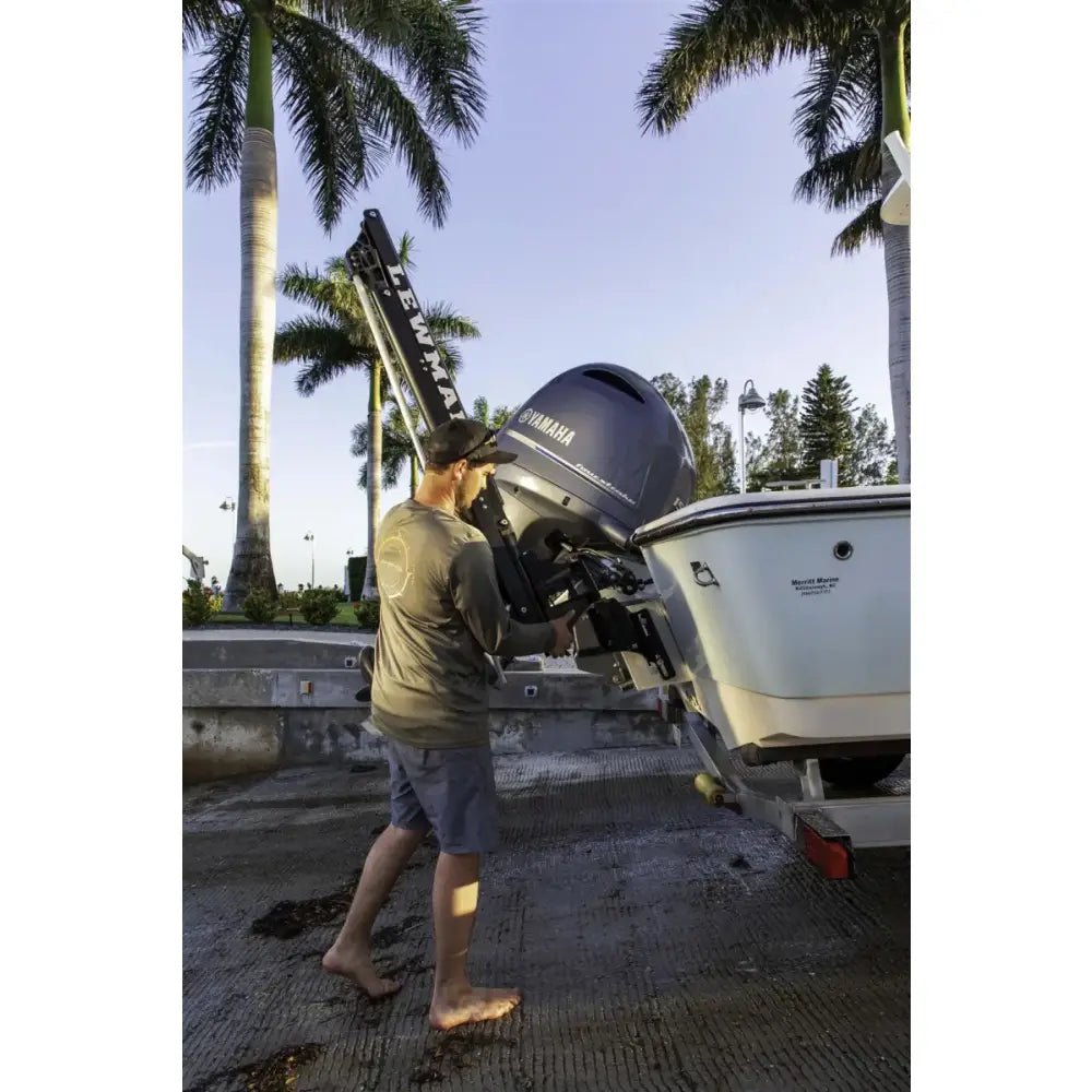 Boat motor being installed with Lewmar Axis Shallow Water Anchor for easy docking