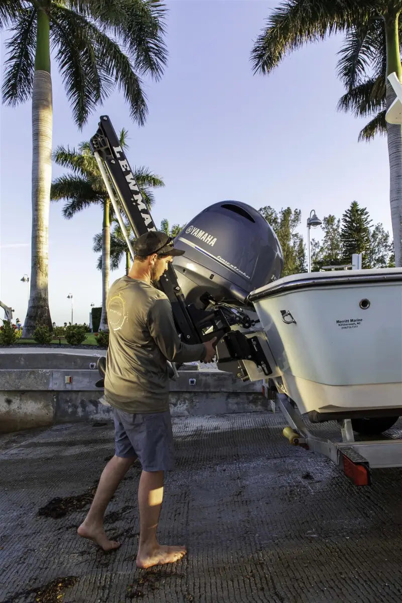 Boat motor being installed with Lewmar Axis Shallow Water Anchor for easy docking