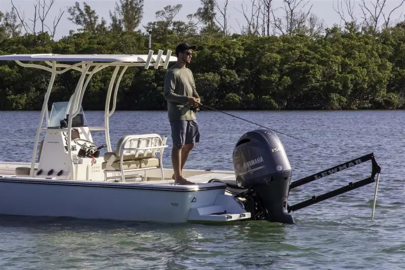 Fishing boat with a man using Lewmar Axis shallow water anchor in action