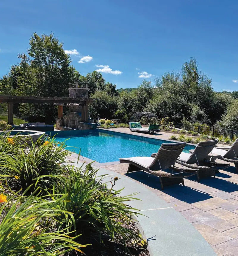 Outdoor swimming pool with stone waterfall, lounge chairs, perfect for Spike Rear Windshield tint