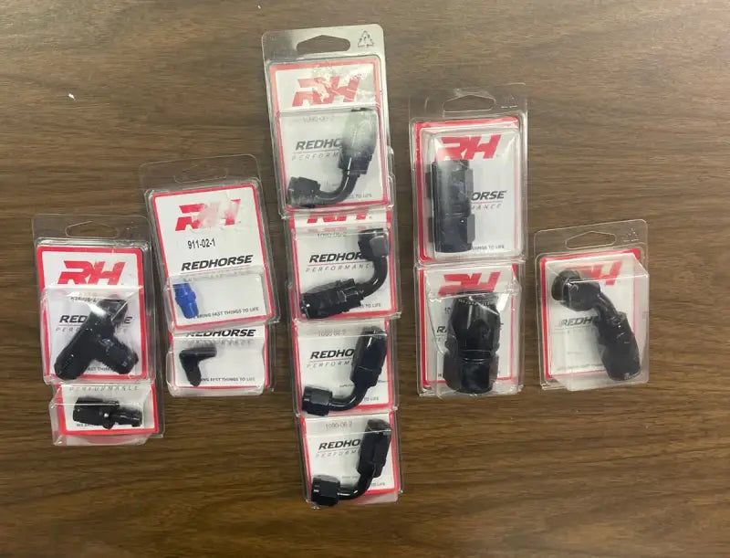 Redhorse Performance 824-08-2 AN to NPT Tee fitting in packaging on a wooden surface.