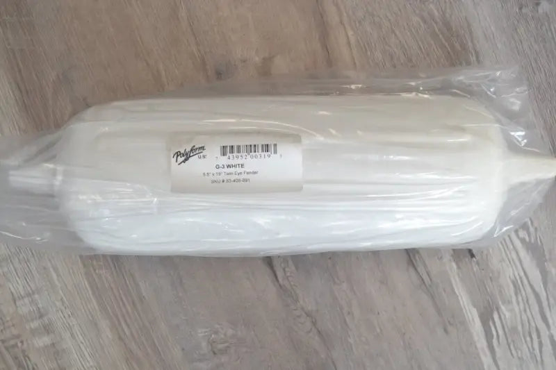 Polyform 83-408-891 5.5' X 19' Twin Eye Fender packaged in plastic wrap, placed on a wooden surface.