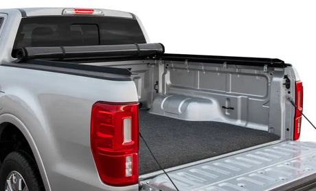 Silver pickup truck bed with Rivian R1T truck bed mat for added protection