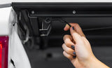 Hand pulling release cord on Access LOMAX tri-fold cover for Toyota Tundra 6ft 6in bed