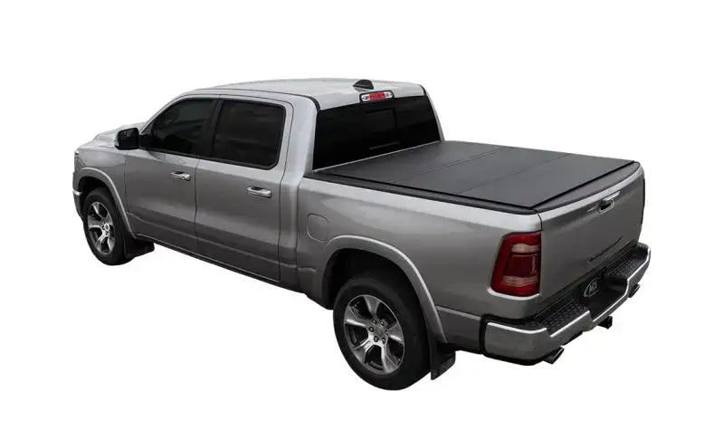 Silver pickup truck with access lomax tri-fold cover on 09-18 Ram 1500 bed
