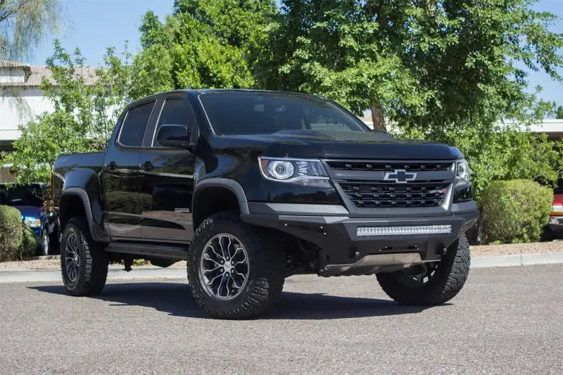 Black Chevy Colorado with lifted suspension and custom wheels, featuring Addictive Desert Designs Stealth Fighter bumper