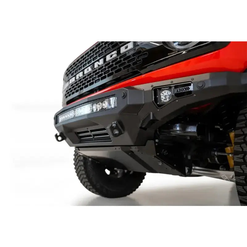 Addictive Desert Designs 2021+ Ford Bronco Stealth Fighter Front Bumper with Winch Mount in hammer black and satin black finish, featuring light bar and cube light mounts.