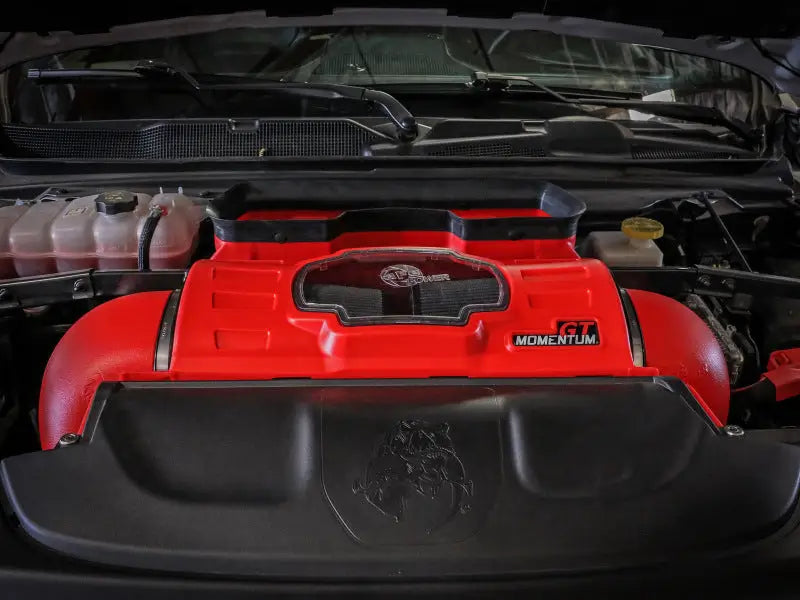 aFe Momentum GT Intake system installed in a Dodge RAM 1500 TRX V8-6.2L engine bay, featuring a vibrant red filter housing with a clear sight window.