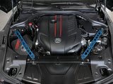 Engine bay of a Toyota GR Supra with aFe Control suspension strut brace and blue accents