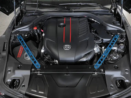 Engine bay of a Toyota GR Supra with aFe Control suspension strut brace and blue accents