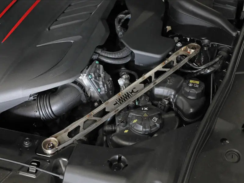 Metallic suspension strut brace installed in Toyota GR Supra engine bay for improved stability