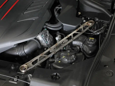 Metallic suspension strut brace installed in Toyota GR Supra engine bay for improved stability