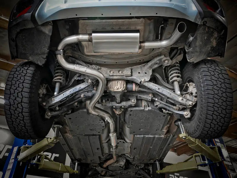 Under view of aFe POWER Takeda 2.5in 304 SS Cat-Back Exhaust System installed on Subaru Crosstrek 18-19 H4-2.0L, showcasing durability and precision engineering.