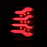 AlphaRex 09-18 Dodge Ram 1500 PRO-Series LED Tail Lights Jet Black, illuminated showing sleek red LED design.