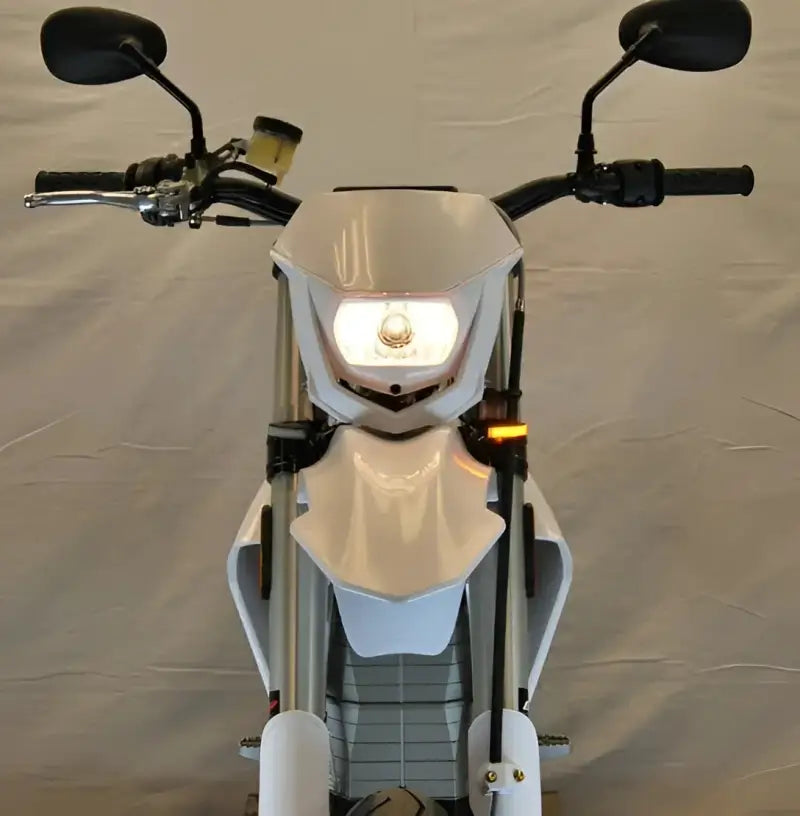 White dirt bike with illuminated headlight and LED turn signals for better visibility