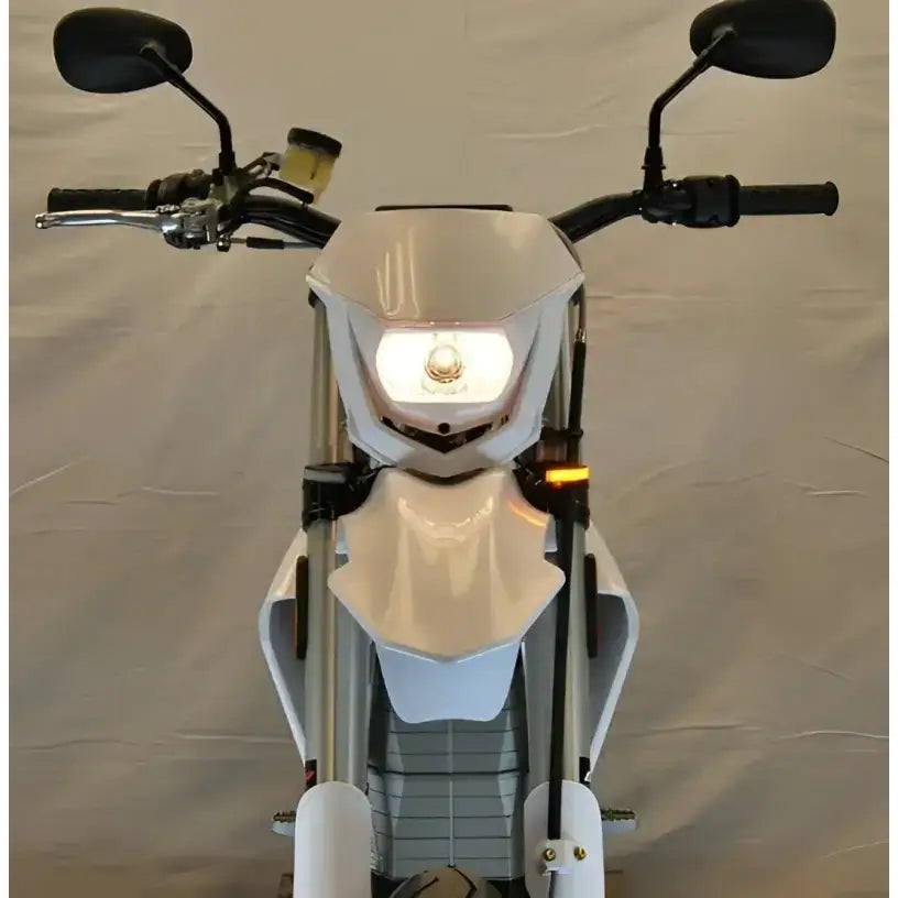 White dirt bike with illuminated headlight and LED turn signals for better visibility