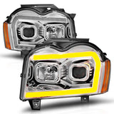 Two aftermarket Jeep Grand Cherokee headlights with LED light bar and switchback chrome housing