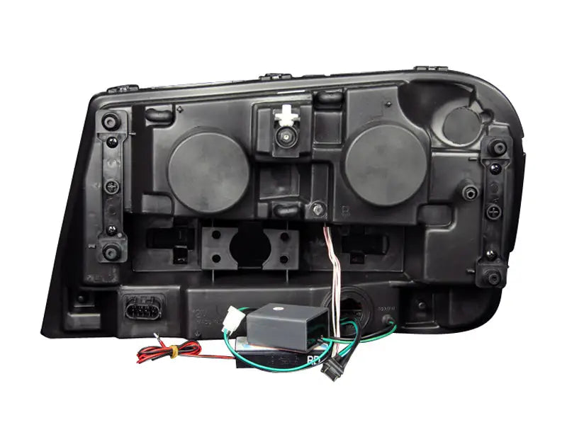 Rear view of black Chevrolet Trailblazer projector headlight set with wiring and connectors