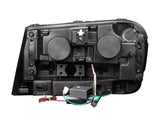 Rear view of black Chevrolet Trailblazer projector headlight set with wiring and connectors
