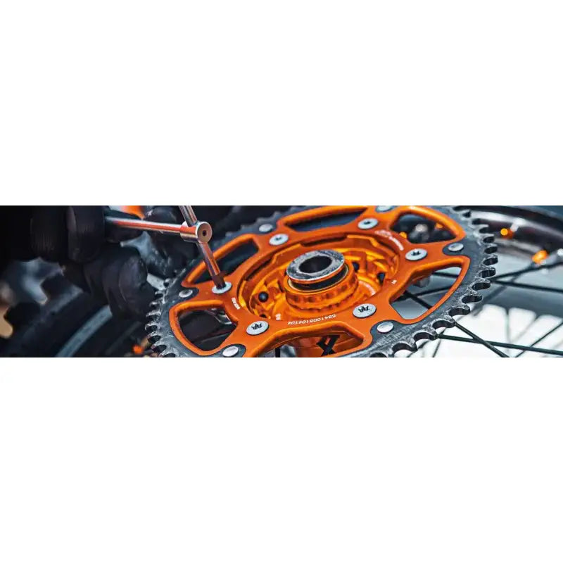 Orange and silver rear steel sprocket being worked on for BikeMaster Suzuki 428 51T