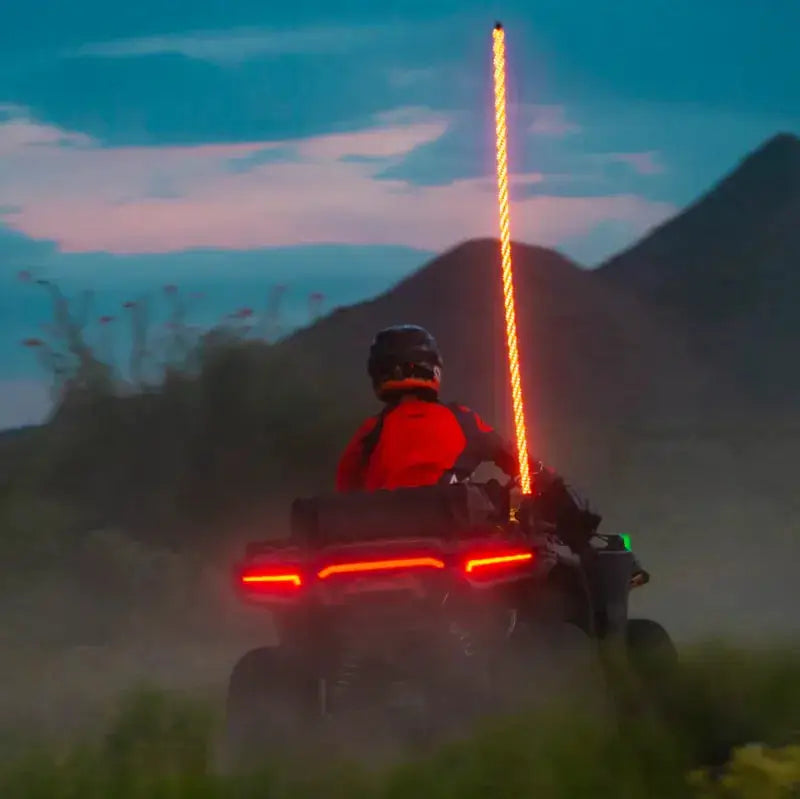 Illuminated ATV with rider featuring Boss Audio Systems ATV whip antenna in multicolor