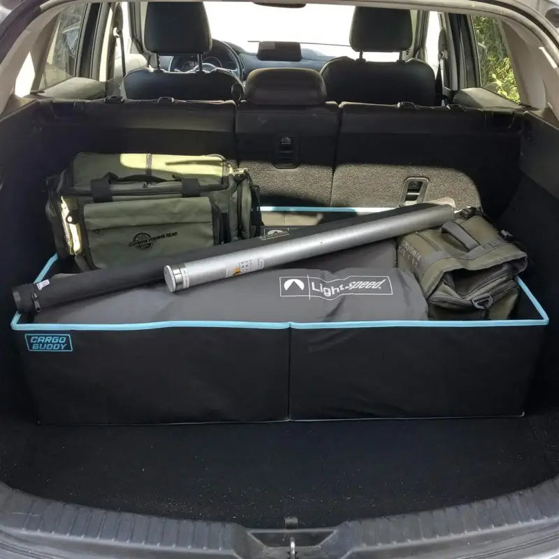 Cargo Buddy mid-size cargo organizer in the cargo area of an SUV, featuring a single compartment, collapsible, black polyester, with outdoor gear items stored inside.