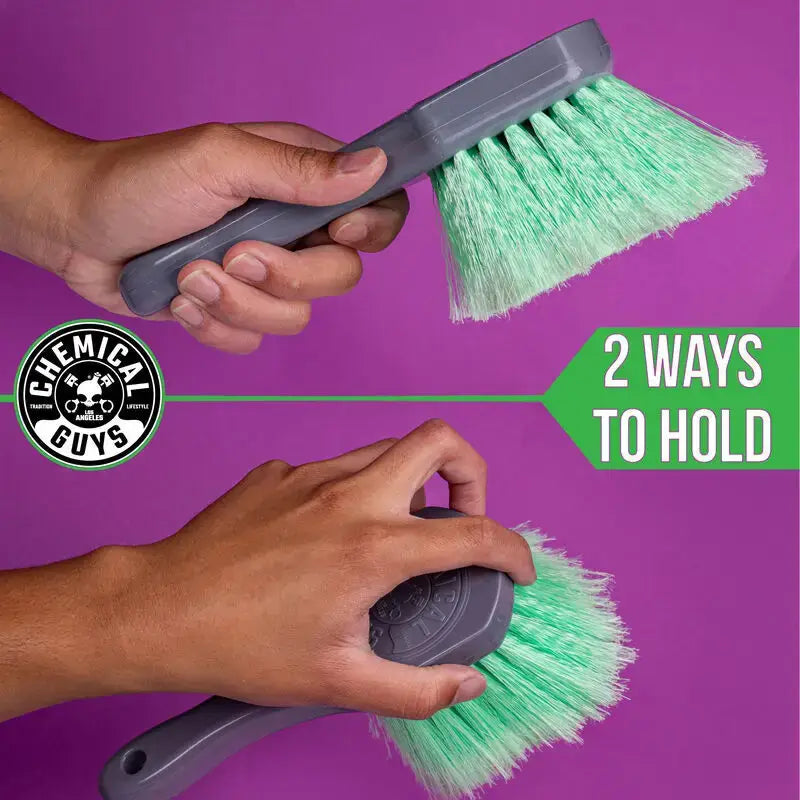 Two-handed green-bristled Chemical Guys Wheelie Wheel & Tire Brush for cleaning tires