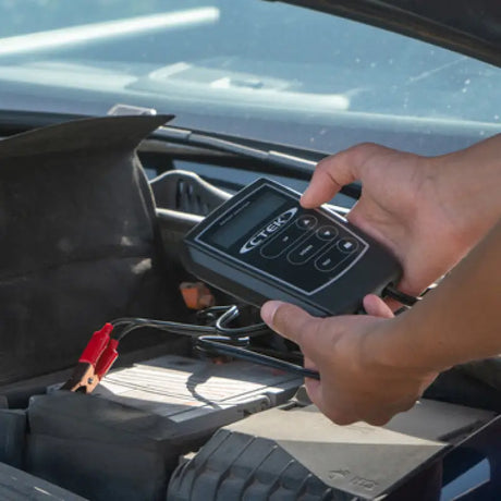 Person testing a 12V battery with CTEK Accessory 12V battery analyzer