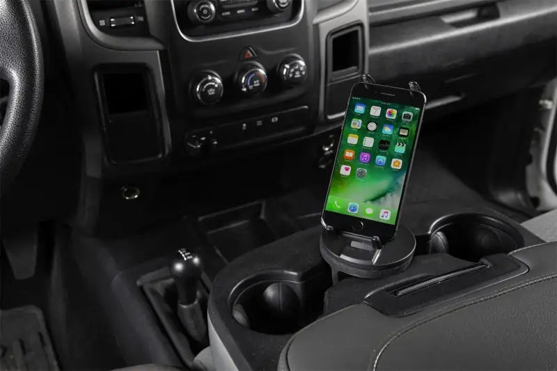 Daystar Universal Hands-Free Phone Grip securely holding a smartphone in a vehicle's cup holder, showcasing 360° view rotation and full charger port access. Ideal for RV, Automotive, Powersports, off-road, marine, exterior, truck accessories, interior, truck bed, RV parts, Truck & Automotive, AVADA - Best Sellers.