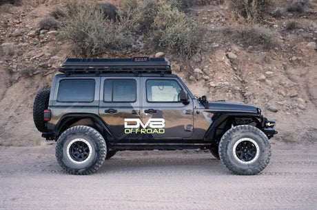 DV8 Offroad 18-23 Wrangler JL/Gladiator JT Spec Series Front Bumper on a black Jeep with high clearance design, off-road-ready in desert terrain.
